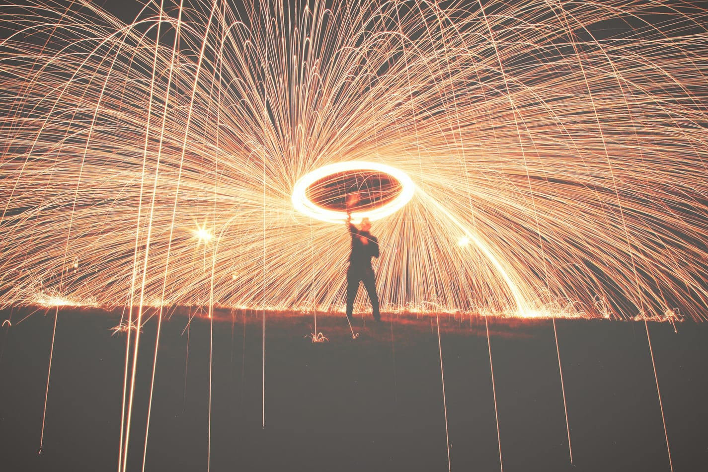 Person with a ring of fire above them, sparks flying all over